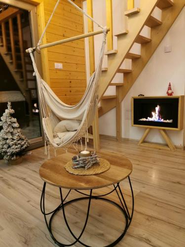 a hammock chair in a living room with a fireplace at Loft&Hill in Grywałd