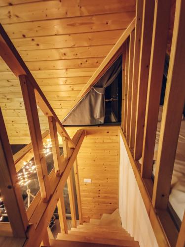 a staircase in a log cabin with wooden ceilings at Loft&Hill in Grywałd
