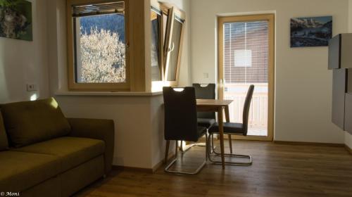 a living room with a couch and a table and a window at Haus Timmler in Sankt Anton am Arlberg