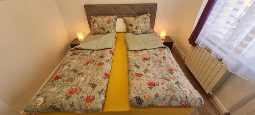 two beds in a small room with two candles at JULIJA apartment in Belgrade