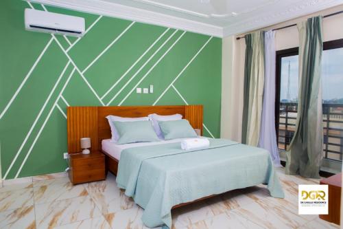 ドゥアラにあるDe Gaulle Residenceの緑の壁のベッドルーム1室