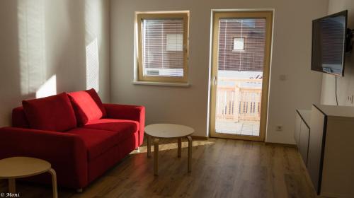 a living room with a red couch and a table at Haus Timmler in Sankt Anton am Arlberg