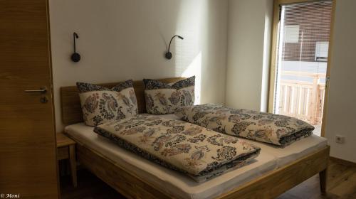 a bed with pillows on it with a window at Haus Timmler in Sankt Anton am Arlberg
