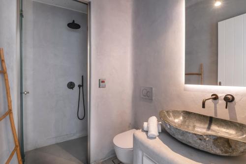 y baño con lavabo de piedra grande y aseo. en My Castle House - MG Villas Mykonos en Fanari