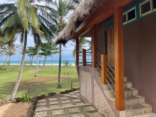 a building with a porch with a view of the ocean at Turtles Nest Bunkhouse at Lodge at Long Bay in Corn Island