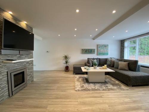 a living room with a couch and a table and a tv at Modern 3-Bedroom villa, 3 Parking Spaces, WiFi in Oxford