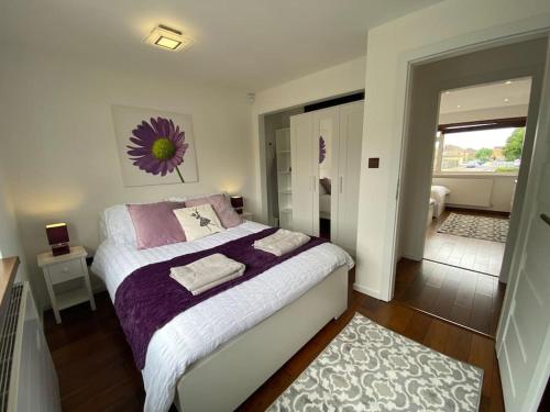 a bedroom with a bed with purple and white sheets at Modern 3-Bedroom villa, 3 Parking Spaces, WiFi in Oxford