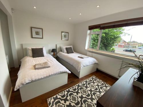 a bedroom with two beds and a window at Modern 3-Bedroom villa, 3 Parking Spaces, WiFi in Oxford