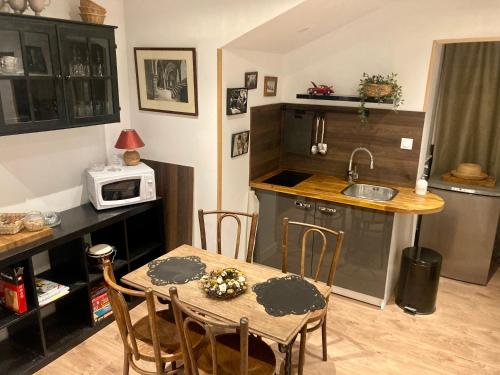 uma cozinha com uma mesa e uma pequena cozinha com um micro-ondas em Provins cité médiévale em Provins