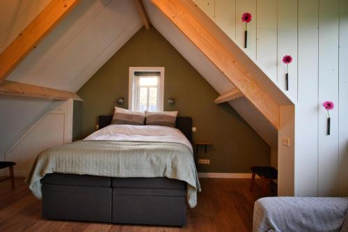 a bedroom with a bed in the attic at Het Gouwe Boetje in Hoogwoud