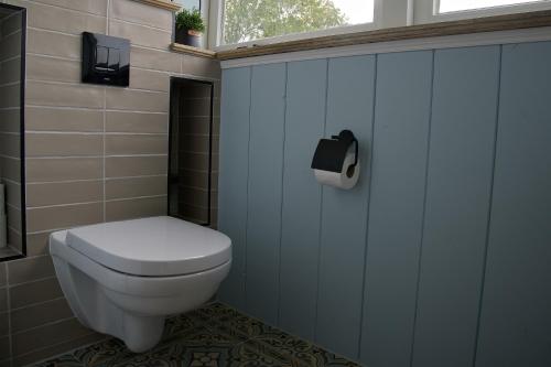 a bathroom with a toilet and a toilet paper dispenser at Het Gouwe Boetje in Hoogwoud