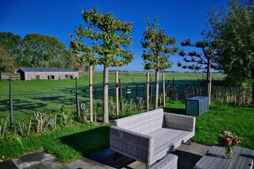 a white couch sitting in the middle of a yard at Het Gouwe Boetje in Hoogwoud