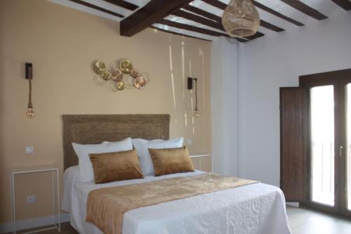 una camera da letto con un grande letto bianco con cuscini di Casa Rural La Labranza a Sacedón