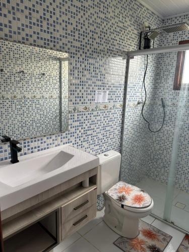 a bathroom with a toilet and a sink and a shower at Pousada Fabia e Fabio in São Gabriel