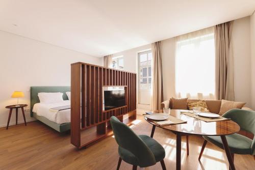 sala de estar con cama, mesa y sillas en RIBEIRA FLORES 59 Downtown Apartments, en Oporto