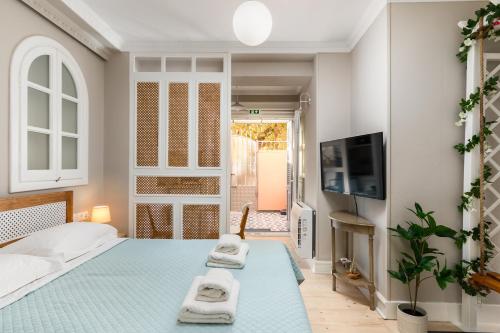 a bedroom with a bed with two towels on a blue floor at Well Apartments by Skyloft Corfu in Anemómylos