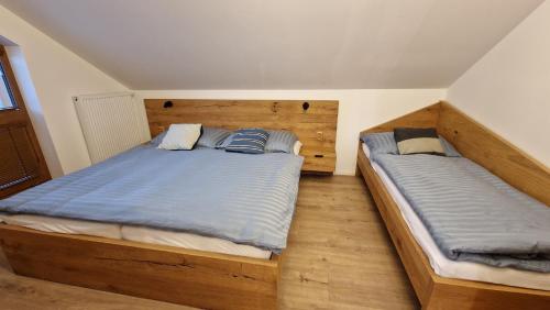 two twin beds in a bedroom with wooden floors at Mytho 1 in Mýto pod Ďumbierom