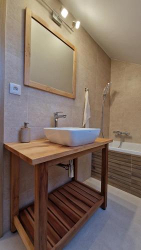 a bathroom with a large white sink on a wooden table at Mytho 1 in Mýto pod Ďumbierom