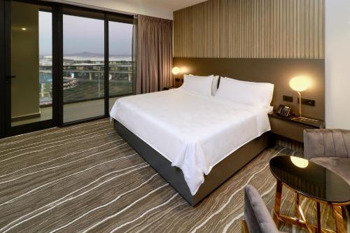 a hotel room with a bed and a large window at Holiday Inn & Suites - Mexico Felipe Angeles Airport by IHG in Zumpango de Ocampo
