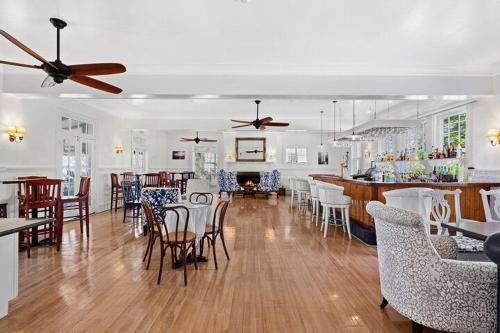 a room with a bar with chairs and a dining room at Rams Head Inn in Shelter Island