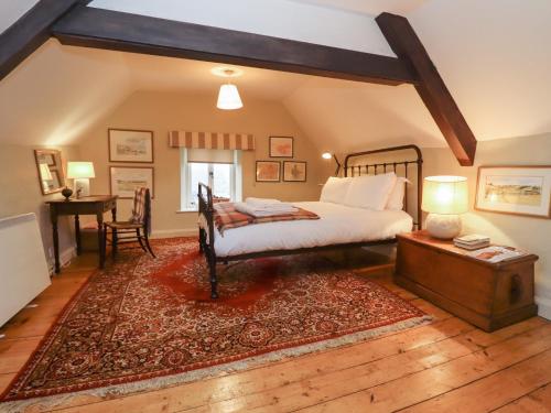 a bedroom with a bed and a table and a desk at The Doll's House in Cheltenham