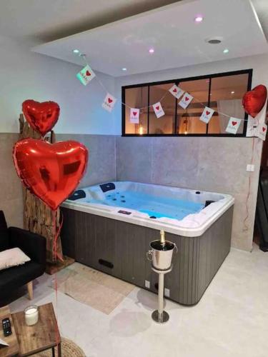 a hot tub in a living room with a red heart at Appartement - Spa in Monteux