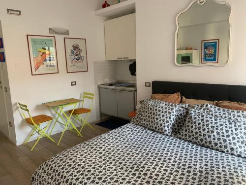 a bedroom with a bed and a table and a kitchen at Studio Campofiore in Verona
