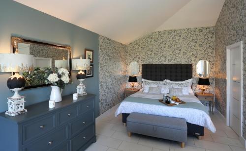 a bedroom with a bed and a dresser and a mirror at Boat House Lodge in Shrewsbury