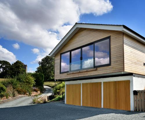 a house with glass windows and a driveway at Boat House Lodge in Shrewsbury