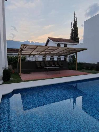 a house with a pavilion next to a swimming pool at Hermoso Dpto a pasos del Fashion Drive c/alberca in Monterrey