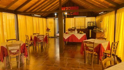 a dining room with tables and chairs and yellow curtains at Motorrad-Hotel Toskana con piscina e giardino nel Chianti in Montespertoli
