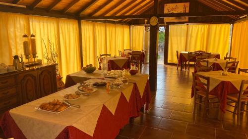 a dining room with two tables with food on them at Motorrad-Hotel Toskana con piscina e giardino nel Chianti in Montespertoli