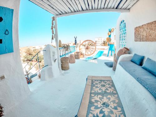 a living room with a blue couch on a balcony at El houch الحوش in Port El Kantaoui