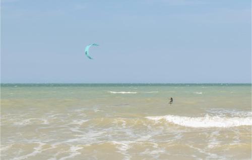 a person in the ocean flying a kite at Nice Home In Saint-Aubin-Sur-Mer in Saint-Aubin-sur-Mer