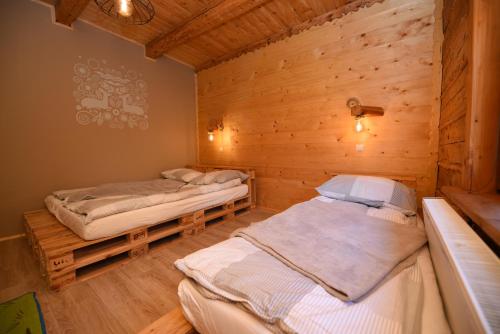 - 2 lits dans une chambre dotée de murs en bois dans l'établissement Chata Kaimówka, à Szczyrk