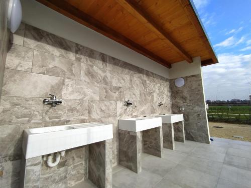 two sinks in a bathroom with a stone wall at Agricamping Corte Pianton in Pacengo di Lazise