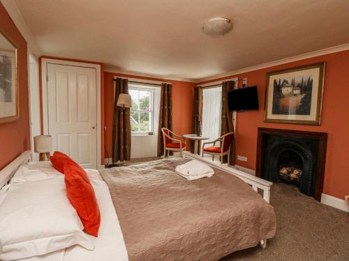 1 dormitorio con 1 cama y chimenea en The House at Bridge of Lochay, en Killin