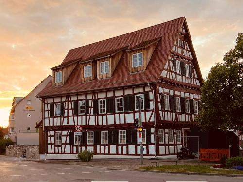 a large wooden building with a brown roof at Rose Boardinghouse in Großbottwar