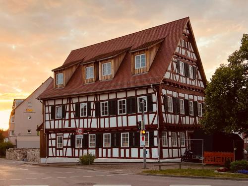 ein großes Holzgebäude mit braunem Dach in der Unterkunft Rose Boardinghouse in Großbottwar