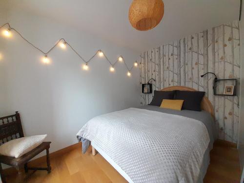 - une chambre dotée d'un lit avec des lumières sur le mur dans l'établissement Côté Château, à Gaillon