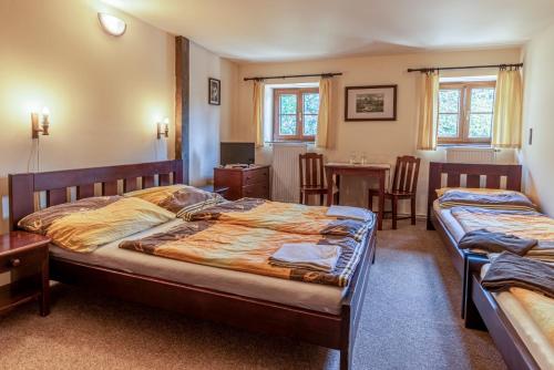 a bedroom with two beds and a table and chairs at Hájenka Knížecí Pláně in Borová Lada