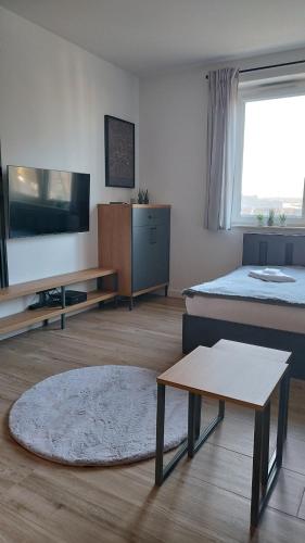 a living room with a bed and a table and a couch at Apartment Between in Kraków
