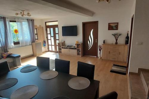 a dining room with a table and chairs in a living room at Casa Happy Family Bran in Bran