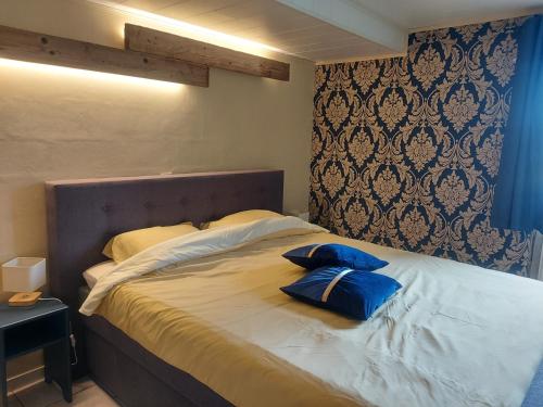 uma cama com duas almofadas azuis em cima em A mon Châl em Waimes