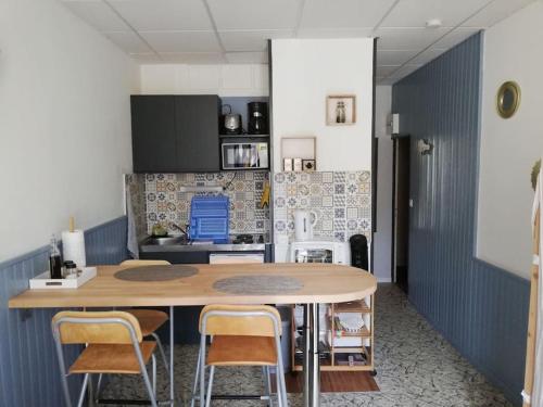 een keuken met een tafel en stoelen in een kamer bij Le nid douillet Univers in La Bourboule
