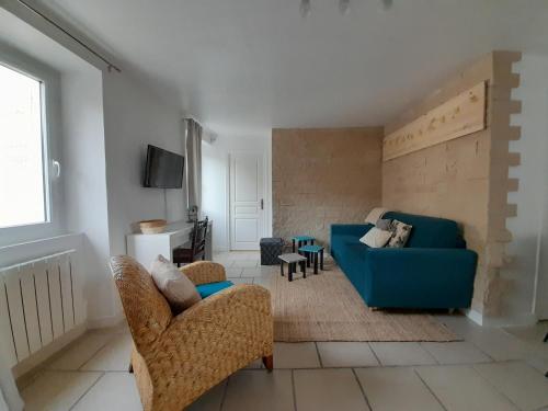 ein Wohnzimmer mit einem blauen Sofa und Stühlen in der Unterkunft Côté Château in Gaillon