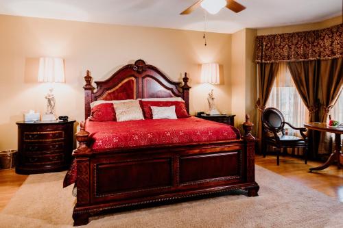 Schlafzimmer mit einem großen Holzbett mit roter Bettwäsche in der Unterkunft 1897 Beekman House Bed and Breakfast in Dundee