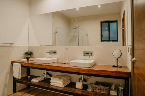 a bathroom with two sinks and a large mirror at Villa Montefiori in Valle de Guadalupe