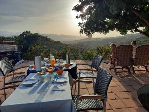 a table with a blue table cloth with a view at Casa Montaña Vélez-Málaga B&B in Vélez-Málaga