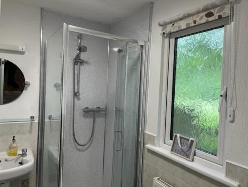 baño con ducha, lavabo y ventana en Family Holidays Blackpool, en Blackpool